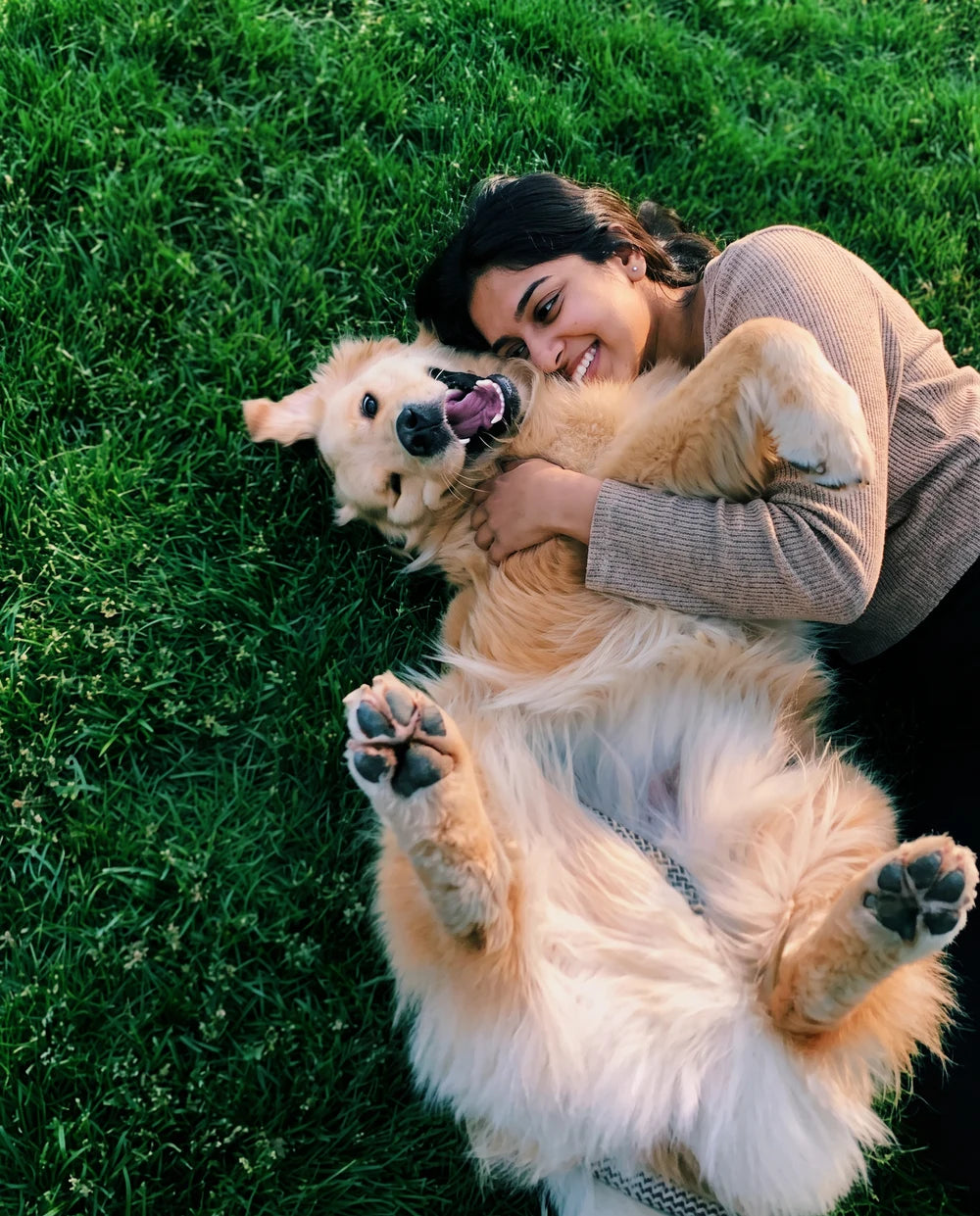 A pet parent cuddling her golden retriever